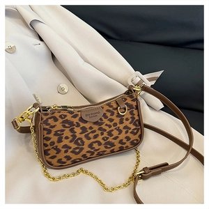 Detailed macro view of leopard print crossbody bag with gold chain and leather trim