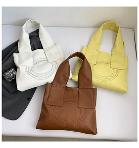 Minimalist tote bags in white yellow and brown colors featuring artistic oval patterns