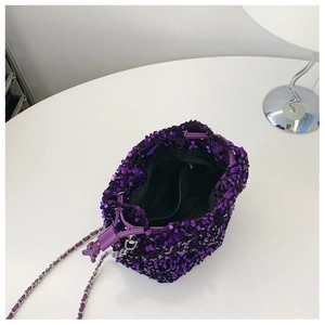 Dettaglio dall'alto del secchiello di paillettes viola con coulisse e tracolla a catena