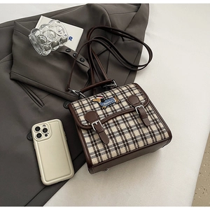 Detail of vintage plaid crossbody bag with cute dachshund embroidery and leather strap
