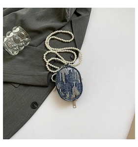 Détail du mini sac en denim bleu avec paillettes argentées et chaîne en perles blanches