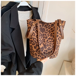 Detailed view of leopard print bucket bag with brown faux leather straps and brand logo