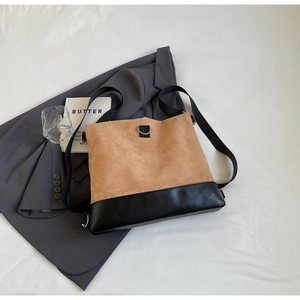 Detail of large tote bag showing suede and black leather stitching with wide strap