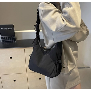 Detail van zwarte nylon wolktas met geplooide schouderband en accenten met trekkoordjes