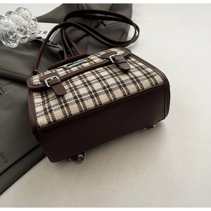 Detail of vintage plaid and brown leather拼接 flap backpack with silver metal buckles