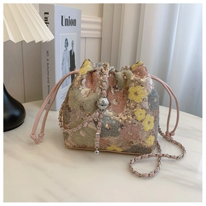 Dettaglio della borsa a secchiello con paillettes floreali, chiusura a coulisse e sfere argento