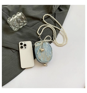 Vue détaillée d'une mini pochette en jean à paillettes avec sangle en perles et nœud