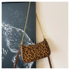 Detail of leopard print fabric texture and golden chain strap on a vintage handbag