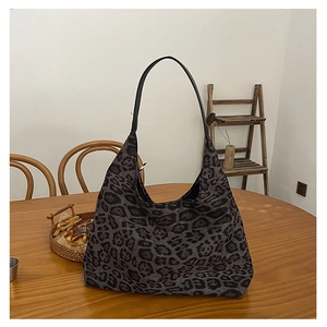 Detailed view of leopard print tote bag on a wooden table in a cozy indoor setting