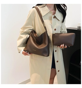 Detail of dark brown leather bucket bag and pouch with adjustable wide shoulder strap
