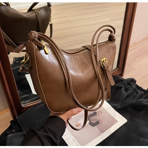 Detailed macro view of the brown leather hobo bag showing texture and knot detail