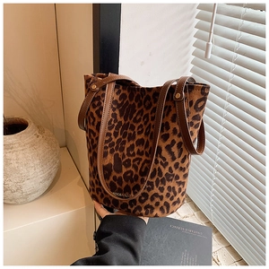Close-up of leopard print faux fur bucket bag with brown handles and gold logo detail