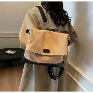 Detail view of large capacity messenger bag with wide strap on trench coat model