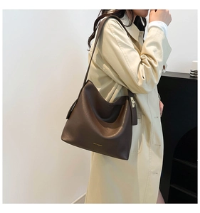 Detail of a vintage dark brown hobo bag showing golden logo and metallic swivel lock