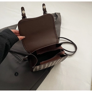 Detailed view of plaid backpack interior featuring multiple compartments and zip pocket