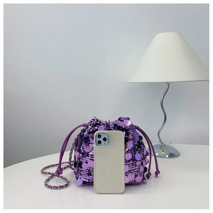 Dettaglio della borsa a secchiello con paillettes viola, coulisse e catena argento e telefono