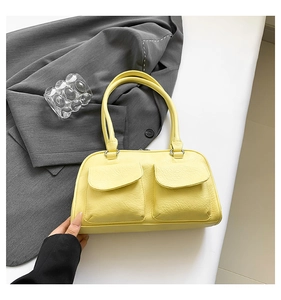 Detail of lemon yellow faux leather shoulder bag with textured surface and twin pockets