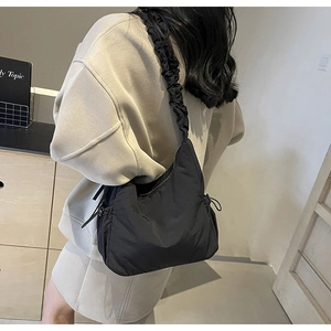 Detail van de zwarte nylon cloud-tas met geplooide schouderband met trekkoord op model