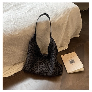 Detail of vintage leopard print tote bag with soft texture on a natural wooden floor