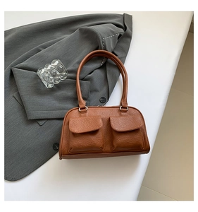 Close-up of brown faux leather shoulder bag featuring textured grain and two front flap pockets