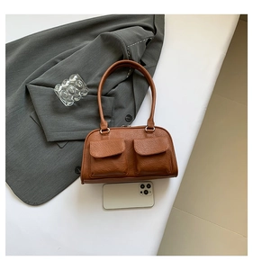 Close-up of vintage brown shoulder bag with lychee texture and two front flap pockets