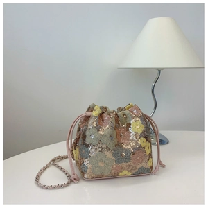 Dettaglio della borsa a secchiello con paillettes floreali e tracolla a catena