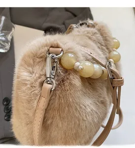 Detail of faux mink leopard bucket bag featuring beaded handle and silver hardware hooks