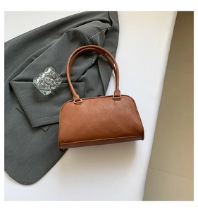 Detailed top view of a brown vintage tote bag with silver rings on white background