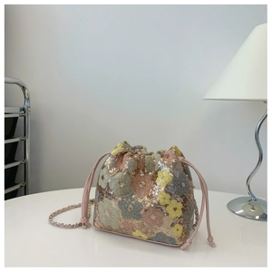 Dettaglio borsa a secchiello con paillettes floreali e coulisse rosa con catena
