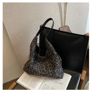 Detail of hobo tote bag featuring vintage leopard print and black leather shoulder strap