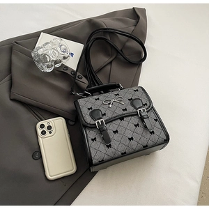 Flat lay of vintage plaid backpack with silver bow buckle and elegant lifestyle props