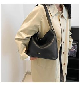 Model showing black large capacity faux leather hobo shoulder bag with golden logo