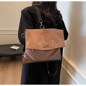 Macro detail of brown suede tote bag featuring reinforced leather edges and brand label
