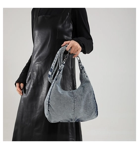 Detailed macro view of light blue washed denim Hobo bag with silver metal hardware