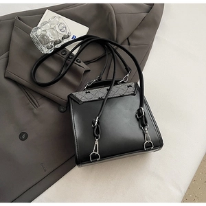 Close-up of black PU leather bag with diamond lattice stitching and bow embroidery details