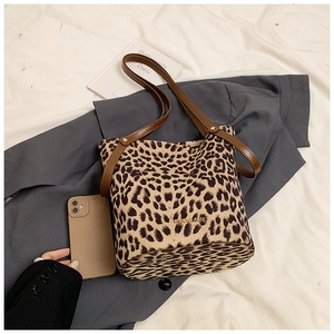 Detailed close-up of leopard print bucket bag with leather strap and golden logo