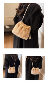 Detail of camel faux fur bucket bag featuring decorative pearly bead handles and a leather strap