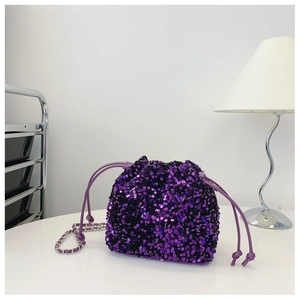 Dettaglio borsa a secchiello con paillettes viola e tracolla a catena d'argento