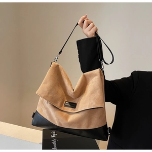 Detail of minimalist suede and black leather patchwork tote with rectangle logo