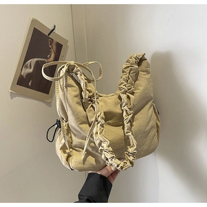 Detailweergave van beige geplooide wolktas van nylon met trekkoordsluiting aan de riem
