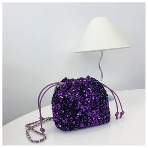 Dettaglio borsa a secchiello con paillettes viola e tracolla a catena d'argento