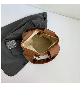 Interior detail of brown pebble leather tote bag with fabric lining and inner pocket