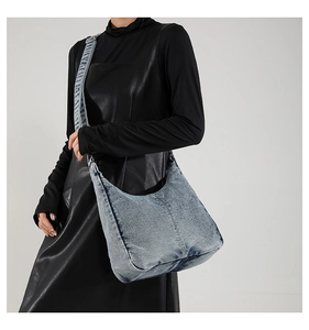 Detailed close-up of retro washed denim hobo bag worn over the shoulder for women