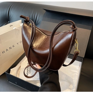 Chocolate brown hobo bag with knotted strap detail in a luxury gift box setting