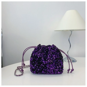 Dettaglio della borsa a secchiello con paillettes viola e tracolla a catena d'argento