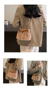 Close-up of faux mink fur crossbody bucket bag with amber bead handle and leather strap