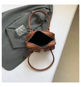 Top view detail showing the zipper opening and brown lychee grain leather texture of the bag
