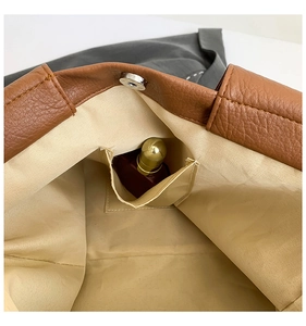 Detail view of large tote interior with beige lining, inner pocket and magnetic silver buckle