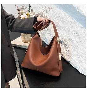 Detail of caramel leather hobo bag with elegant gold hardware buckle in a lifestyle setting
