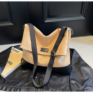 Detail of khaki suede tote bag with black leather base and adjustable wide shoulder strap